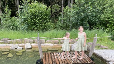 Zwei Kinder auf einem Floß beim überqueeren des Wassers